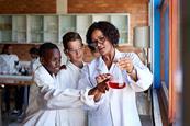 Photo of a teacher and students working together in a classroom. Ideally, the teacher is saying something and the students look like they're repeating after him/her.