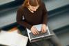 Photo of a student typing on a laptop/computer.