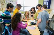 Photo of a teacher and their students, e.g.: in a high school.