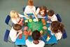 Photo of children in a classroom working in groups or pairs.