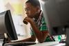 Photo of a child or children in a classroom who look like they're thinking about  something or look very concentrated.