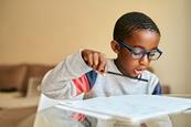 Photo of children drawing, writing or reading.