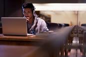 Photo of of a student using their mobile phone or at their laptop, looking something up on the internet.