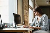 Photo of a teacher writing or reading something, can be on a computer too if it's easier to find.