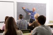 Photo of a teacher and their students in a classroom.