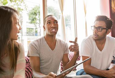 Photo of students speaking to each other in the classroom.