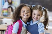 Two kindergarden girls smiling.