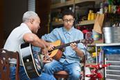 Grandfather and grandson playing guitar